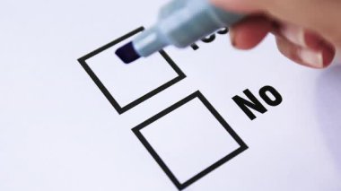 Oy, El bir ankete evet işaretini çizmek için mavi işaret kullanıyor. Onayı, anlaşmayı ya da olumlu kararı sembolize ediyor. Yakın plan.