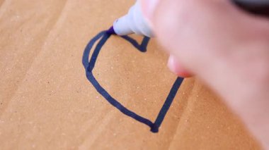 Kalp, Aşk, El kartonda mavi bir işaret olan bir kalp çiziyor. Sevgiyi, sıcaklığı ya da basit duygusal ifadeyi temsil ediyor.