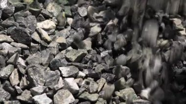 İnşaat çakılları, kaya, taş yığınları, inşaat veya çimento karıştırma sürecinde malzeme kullanımını gösteriyor