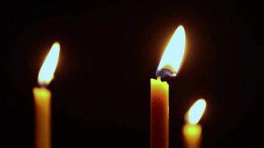 Yanan mum alevleri karanlıkta parlıyor, sıcaklığı, umudu ve anıları simgeliyor. Maneviyat, meditasyon ya da sakin atmosfer kavramları için mükemmel.