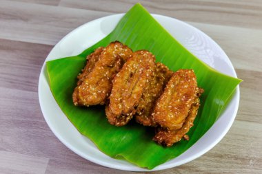 Beyaz bir tabakta muz yaprağında servis edilen kızarmış Tayland muzu, tatlı ve çıtır çıtır dokulu geleneksel Asya atıştırmalığıdır. Üst görüntü görüntüsü