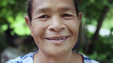 Elderly woman face Happy and Smiled slightly, Portrait elder with facial expression, Close-up portrait grandmother smiling happily on nature garden background, Thai asian