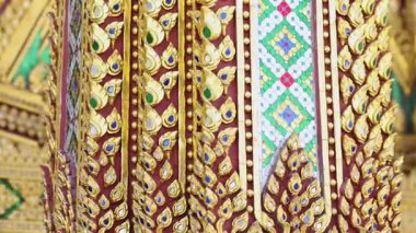 Public Thai temple architecture with traditional golden mosaic and colorful decoration for background, representing cultural heritage and public art in Thailand