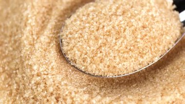 Granüllü esmer şeker, kaşık kepçeli kahverengi şeker tanecikleri, yakın plan, doku detaylarını gösteriyor. içecek yiyecek, malzeme ve tatlı konsepti için.