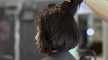 Bir kadının kuaförde saçını kestirmesi, kuaförünün kısa saç kesimi, kendine güvenen ve rahat görünmesi, güzellik ve kendine özen göstermesi, kuaförlük sanatı.