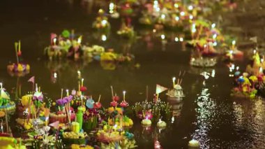 Tayland 'daki Loy Krathong festivali sırasında suda yüzen Krathonglar gece mum ışıklarını güzel yansıtıyorlar, kirli su, kutlamalardan sonra çevresel atıkları yansıtıyorlar.