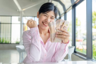 Para, Cash, Varlık, Heyecanlı Asyalı kadın Tayland baht banknotlarını tutuyor ve finansal başarıyı parlak bir gülümseme ve kazanan bir jestle kutluyor.