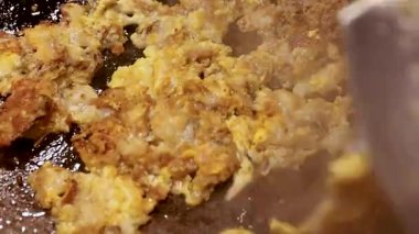 Sıcak tavada kızartılmış Tayland usulü istiridye omleti. Lezzetli sokak yemekleri. Altın dokusunu ve sıcak yemek pişirme atmosferini gösteriyor.