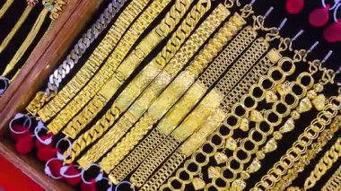 Altın mücevherler, altın bilezikler ve mücevher mağazası vitrininde sergilenen kolyeler zenginliği, yatırımı ve lüksü simgeliyor. Finansal, ekonomik veya altın piyasası kavramları için mükemmel