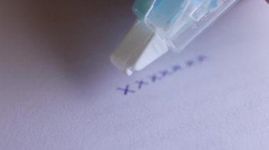 Kağıt üzerindeki mavi kalem izlerini kapsayan düzeltme bandı, düzenleme, düzeltme hataları ve belge doğruluğu temsil ediyor