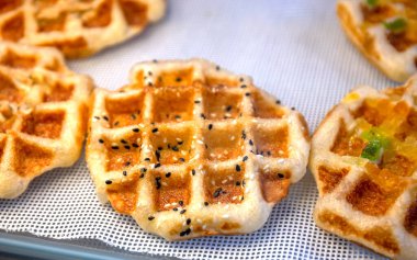 Waffle, rafta altın fırınlanmış waffle, yakın plan Waffle dükkanı, çıtır çıtır ve iştah açıcı bir dokuma. Yemek tasarımı, menüler ve fırın reklamı için mükemmel.
