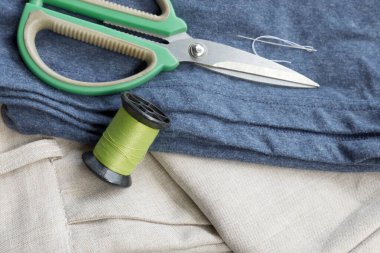 Makas, mavi kumaş ve yeşil iplik makarası gibi dikiş araçları, terzilik, el işi ve DIY projeleri için mükemmel, Üst görünüm