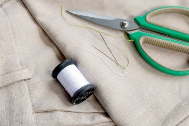 Keten kumaş üzerinde makas, iğne ve iplik makaraları ile dikiş aletleri, terzilik ve el işi projeleri için mükemmel, Top view