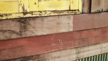 Eski ahşap duvar ve ahşap bir duvar kabuk soyma dokusuyla sarıya boyanmış, yaşlanmış, kırsal bir yüzeyi ortaya çıkarıyor. Klasik, sanatsal ve dokulu arka plan görüntüleri için ideal