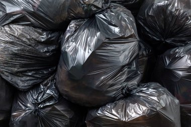 Atık, siyah çöp torbası yığını, plastik atık sorunu ve çevre kirliliği, plastik atık, geri dönüşüm ve atık yönetimi kavramına uygun