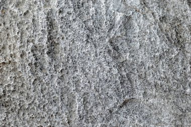 Doğal gözenek ve ayrıntılı desenlere sahip pürüzlü gri taş dokusu, ham ve organik bir görünüm sunuyor, arka planlar için ideal, tasarım yüzeyleri ve doğal temalı projeler için.