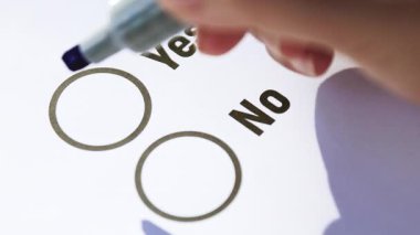 Oylama, El 'in bir ankette evet işaretini işaretlemesi olumlu kararı, onayı ve kendine güveni simgeliyor. Yakın plan.