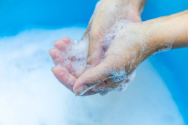 Temiz suda sabun ve köpükle yıkama, yakın çekim, ellerini yıkama hijyen, temizlik, hastalık önleme ve sağlık için sürdürülebilir su kullanımı