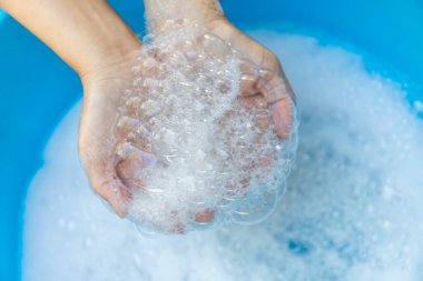Temiz suda sabun tutan sabun köpükleri, yakın çekim, el temizliği, temizlik, el yıkama, el yıkama rutini ve sağlık hizmetleri yoluyla hastalık önleme.