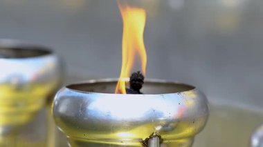 Candle flame in metal cup with warm glow. close-up, Calm and peaceful atmosphere, symbolizing meditation, ritual, hope, spirituality, and relaxation