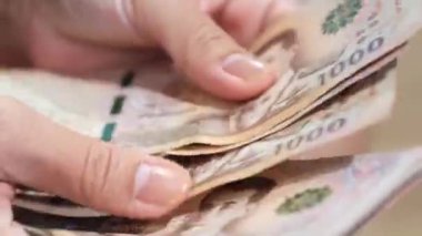 Banknotları sayan eller, yakın plan Tayland parası. Finans, nakit akışını, tasarrufu, harcamaları, harcamaları ve bütçe yönetimini sembolize eder
