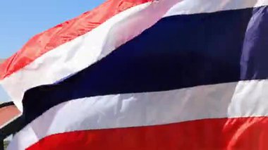Tayland ulusal bayrağı açık mavi gökyüzüne karşı sallanıyor, vatanseverliğin, özgürlüğün ve ulusal kimliğin sembolü. Ülke, kültür, bağımsızlık ve kutlama kavramları için ideal