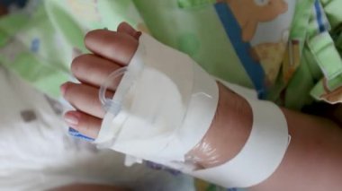 Hastanede serumla çocuk eli, yakın plan, pediatrik sağlık, tıbbi tedavi, hastalık, iyileşme ve hastane bakımını temsil ediyor.