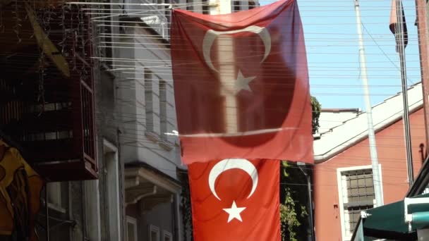 Flagi tureckie machające na ulicy Stambułu między domami — Wideo stockowe