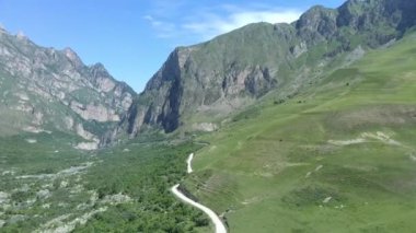 Kafkasya dağlarındaki küçük yolun üzerinde uçan insansız hava aracı manzarası.