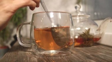 Bir bardak çayın içinde kaşıkla karıştırılmış şeker. Sabah çayı içiyorum.
