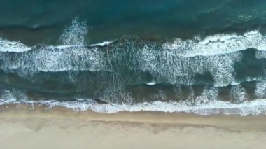 Deniz dalgalarının havadan görünen görüntüsü sahile vuran dalgalar.