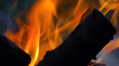 Ateş yakar ve odunu ızgaradaki kömüre çevirir.