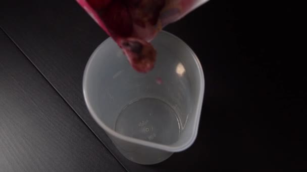 믹서에 섞기 전에 얼어붙은 블루베리와 딸기를 한 컵붓는다. — 비디오