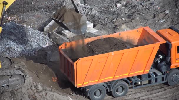 Craler kazıcısı çalışıyor ve inşaat alanındaki çöp kamyonuna yükleniyor. — Stok video