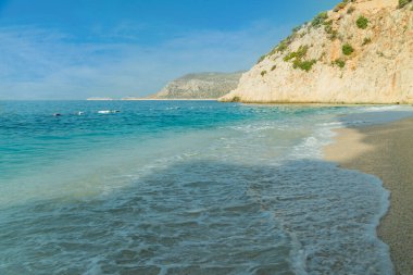 Kaputas plajı, Türkiye. Yazın bir Türk tatil köyünde güneşli turkuaz bir plaj. Seçici odak