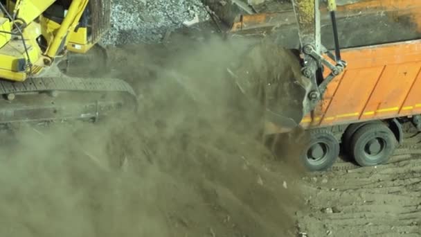 Excavadora de orugas de trabajo y carga en camión volquete en el sitio de construcción. — Vídeos de Stock