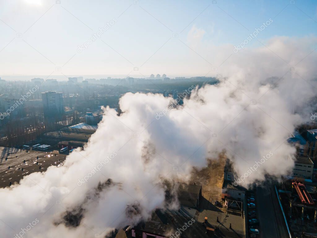Aerial view smoke clouds from boiler pipes on industrial area. Smoking chimney on plant industrial city
