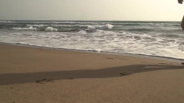 Muž nohy nízký úhel pohledu, běh na písečné pláži podél moře za slunečného dne — Stock video