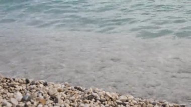 Kiremit plajı ve gevşemiş deniz dalgaları. Yakın plan, arka plan