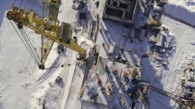 Vinçle inşaat aşamasında olan beton konut binası. İnşaatın havadan görüntüsü beton binanın tepesinde..