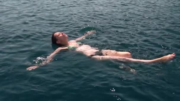 美しい透明ターコイズブルーの海のラグーンで女性の日焼け リラックスして水の中で休んで 泳ぐヒトデのフロート技術をフィット — ストック動画