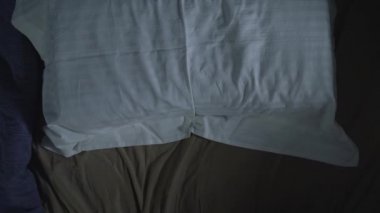 Yorgun adam yastığa düşer ve yorucu bir iş gününden sonra uykuya dalar.