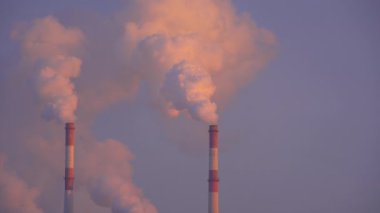 Sanayi bölgesindeki bacadan çıkan sigara dumanlarını yakından çek. Fabrika havasını kirletiyor. Küresel ısınma kavramı