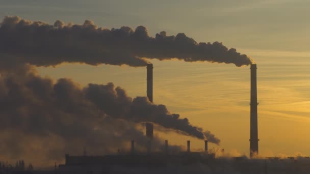 Rook uit industriële fabriek schoorsteen over zonsopgang hemel achtergrond — Stockvideo
