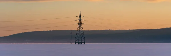 空の日の出の背景を持つ産業用高電圧電気タワー ワイドバナー — ストック写真