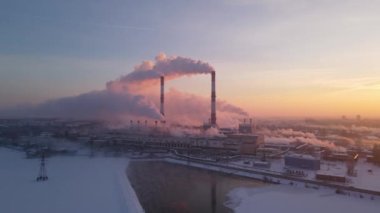 Endüstriyel borulardan atmosfere emisyon. Güneş doğarken çekilen baca boruları.