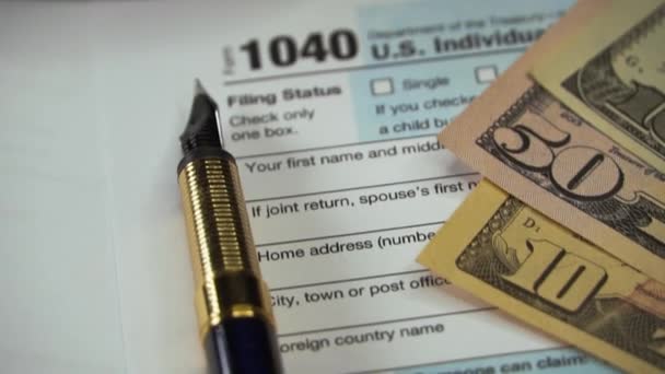 Prázdný formulář 1040 US Individuální přiznání k dani z příjmu s perem a dolarovými bankovkami. Koncept platby daně. Dokument s vyplněnými daněmi