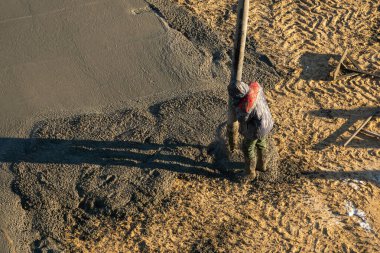 Beton karışımı, inşaat sahasına dökülen işçiler. İşçi pompa tüpü kullanarak çimento ya da beton döker.