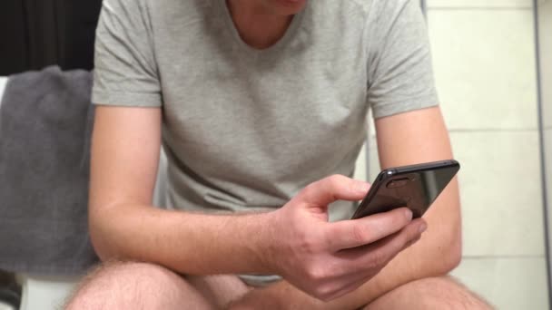 スマホを使って自宅の便器で下痢に苦しむ男 — ストック動画
