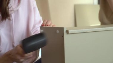 El yapımı mobilya montajı sırasında plastik çekiçle kadın çekiçleri mobilyalara çarpıyor. Yeni eve taşınıyorum.